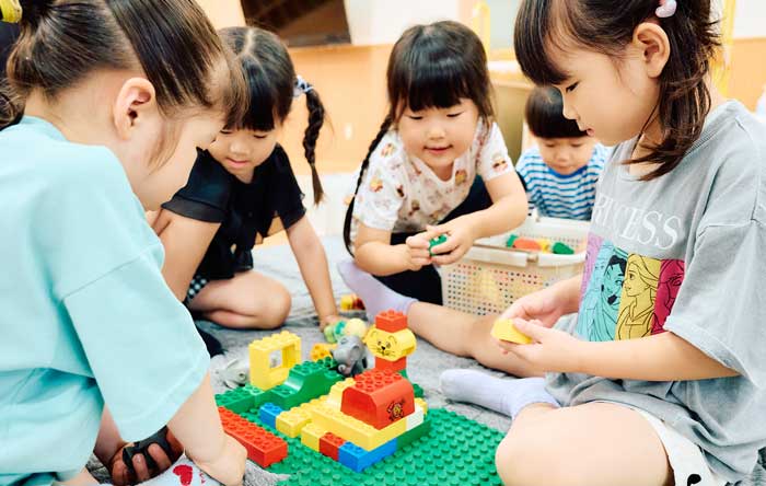 預かり保育で先生と過ごす子どもたち