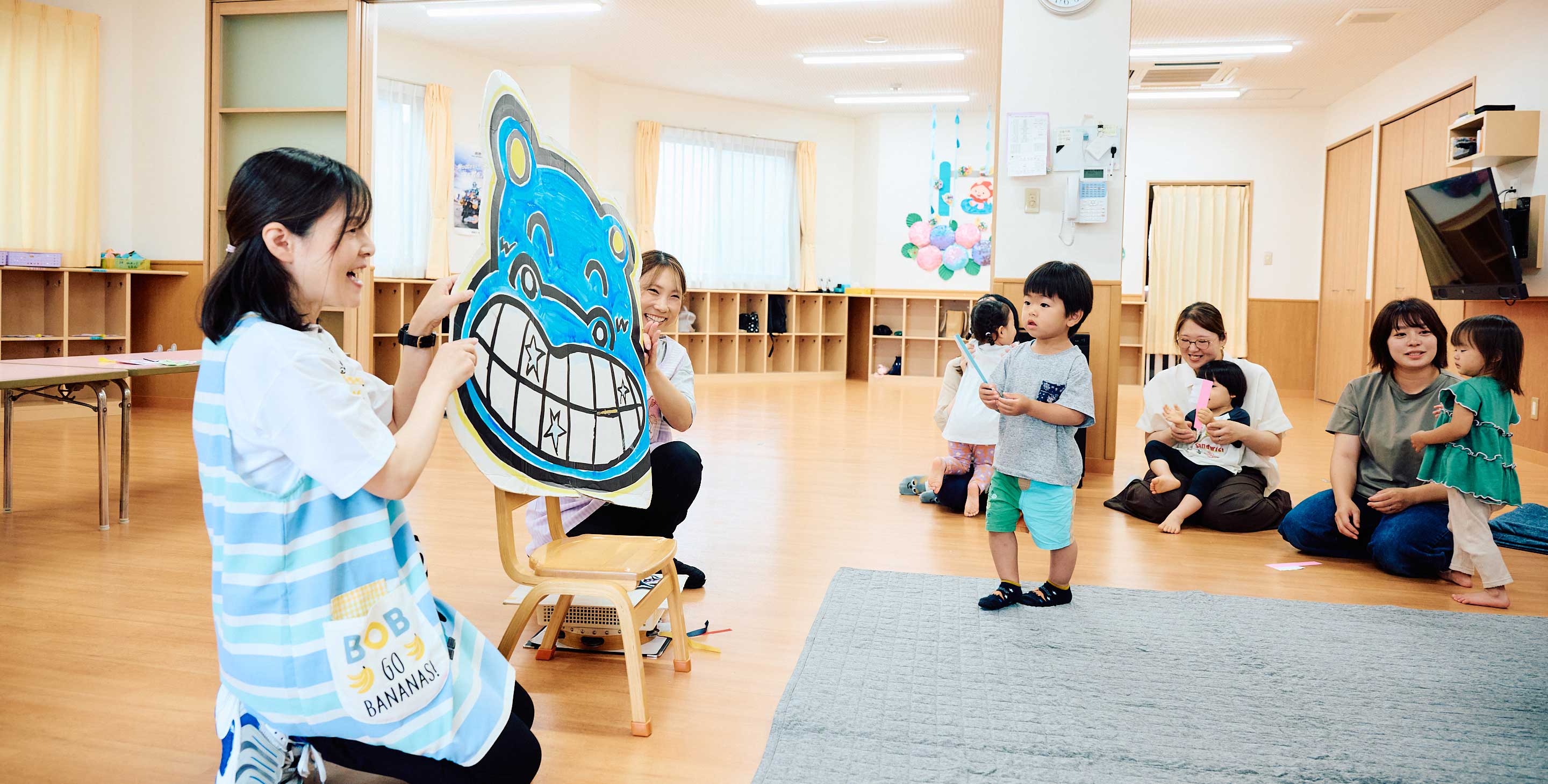 先生と一緒に園体験を楽しむ親子と子どもたち