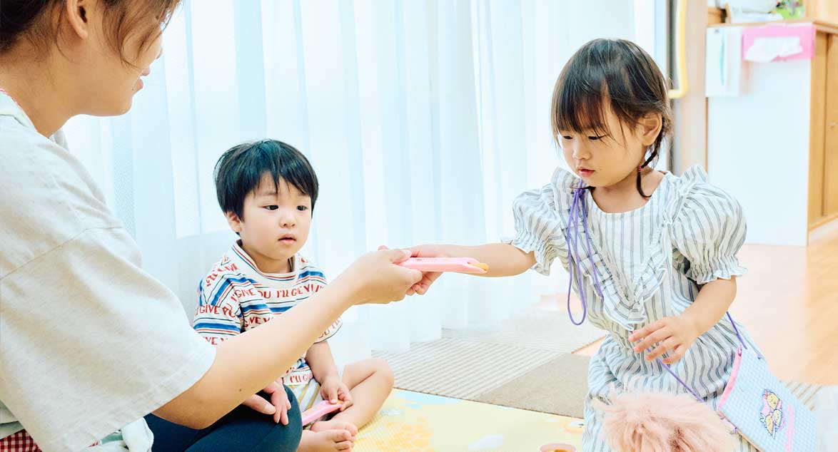 園で先生と過ごす子どもたち
