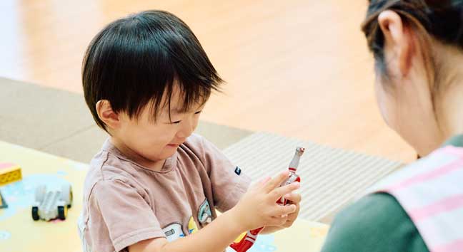 園で先生と一緒に過ごす子どもたち